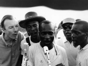 American folk singer and activist Pete Seeger (left) adopted and helped popularize "We Shall Overcome" by teaching the song at rallies and protests. Here he sings with activists in Greenwood, Miss., in 1963. Adger Cowans/Getty Images