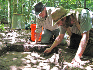 Graduate student Karl Austin and archaeologist Dan Sayers carefully remove soil in tiny increments to reveal traces of a cabin used by escaped slaves in the Great Dismal Swamp. (Marion Blackburn)